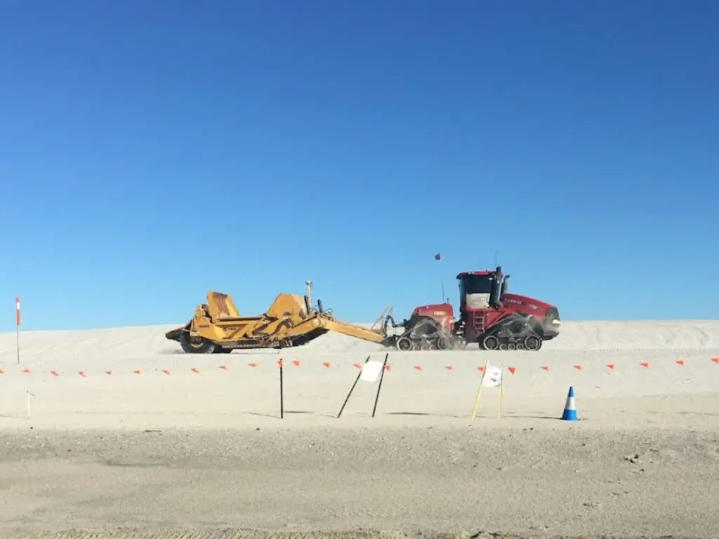 230312 Scraper bucket being dragged by a tractor