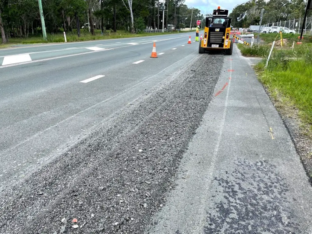 230312 Skid steer with a cold planner on road construction project and ripped road 1